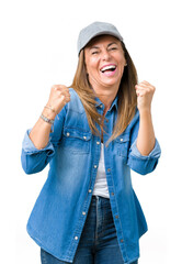 Beautiful middle age woman wearing sport cap over isolated background very happy and excited doing winner gesture with arms raised, smiling and screaming for success. Celebration concept.