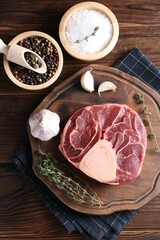 Flat lay composition of raw beef meat and spices on wooden table