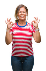 Middle age senior hispanic woman over isolated background relax and smiling with eyes closed doing meditation gesture with fingers. Yoga concept.