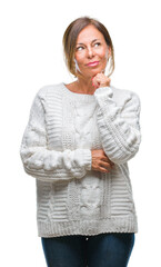 Middle age senior hispanic woman wearing winter sweater over isolated background with hand on chin thinking about question, pensive expression. Smiling with thoughtful face. Doubt concept.
