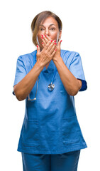 Middle age senior nurse doctor woman over isolated background shocked covering mouth with hands for mistake. Secret concept.
