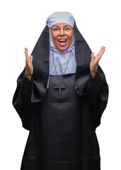 Middle age senior christian catholic nun woman over isolated background celebrating surprised and amazed for success with arms raised and open eyes. Winner concept.