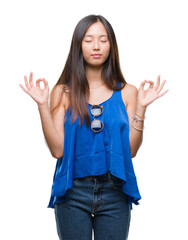 Young asian woman over isolated background relax and smiling with eyes closed doing meditation gesture with fingers. Yoga concept.
