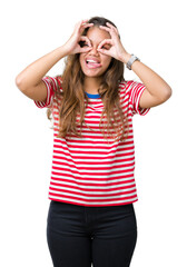 Obraz na płótnie Canvas Young beautiful brunette woman wearing stripes t-shirt over isolated background doing ok gesture like binoculars sticking tongue out, eyes looking through fingers. Crazy expression.