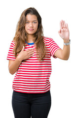 Young beautiful brunette woman wearing stripes t-shirt over isolated background Swearing with hand...