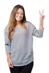 Young beautiful brunette woman wearing stripes sweater over isolated background smiling with happy face winking at the camera doing victory sign. Number two.