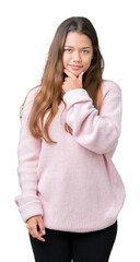 Young beautiful brunette woman wearing pink winter sweater over isolated background looking confident at the camera with smile with crossed arms and hand raised on chin. Thinking positive.