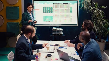 Operations manager develops sales strategies and targets, task based on market dynamics and customer feedback shown on interactive board. Specialist attends a meeting with colleagues. Camera B.