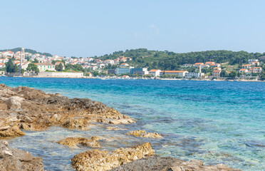 View from rugged rocky coastline across harbour to tourist and fishing township of Hvar