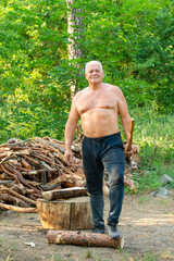 portrait of an elderly man with an ax against a forest background - 781707535