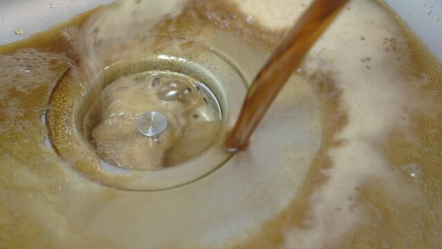 Close-up of brown carbonated drink being poured into steel sink, diet without sweet harmful drink, weight loss proper nutrition Getting rid of sweet drinks, alcohol, bad habit Clear pipe from blockage