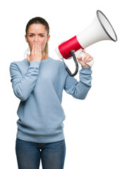 Beautiful young woman holding megaphone cover mouth with hand shocked with shame for mistake, expression of fear, scared in silence, secret concept