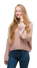 Blonde teenager woman wearing pink sweater touching mouth with hand with painful expression because of toothache or dental illness on teeth. Dentist concept.