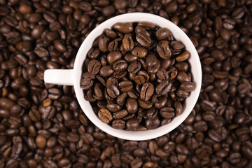 Widok kawy z góry w filiżance udekorowanej rozsypanymi ziarnami  kawy w tle