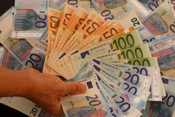 Euro currency banknotes on black background. Exchange money symbol of wealth. Eurozone with currency. The euro is the monetary unit and currency of the European Union