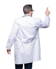 Handsome young doctor man over isolated background Posing backwards pointing behind with finger hand