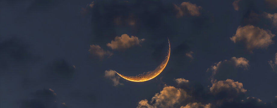 Crescent moon on dark blue twilight sky vertical symbol of religion and well editing text Ramadan Eid Muharram on free space.