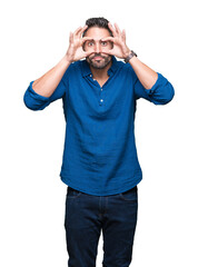 Fototapeta premium Young handsome man over isolated background Trying to open eyes with fingers, sleepy and tired for morning fatigue