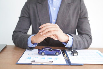 Agent Assurance Securing Deals with Confidence close up man working with car contract document or lease paper at desk in loan car office.