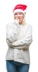 Young beautiful blonde woman wearing christmas hat over isolated background looking stressed and nervous with hands on mouth biting nails. Anxiety problem.