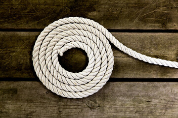 top down view of coiled flaked yacht rope on a wooden dock