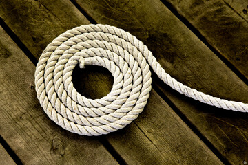 coiled flaked yacht rope on a wooden dock