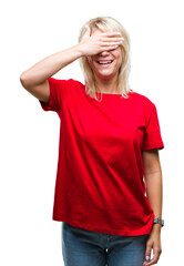 Fototapeta premium Young beautiful blonde woman wearing red t-shirt over isolated background smiling and laughing with hand on face covering eyes for surprise. Blind concept.