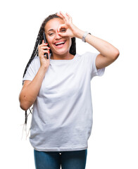 Young braided hair african american girl showing calling using smartphone over isolated background with happy face smiling doing ok sign with hand on eye looking through fingers