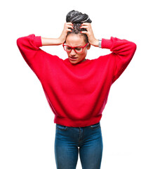Fototapeta premium Young braided hair african american girl wearing sweater and glasses over isolated background suffering from headache desperate and stressed because pain and migraine. Hands on head.