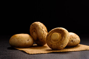 Fresh organic button mushroom placed on black background. Local ingredient for healthy vegetarian meal