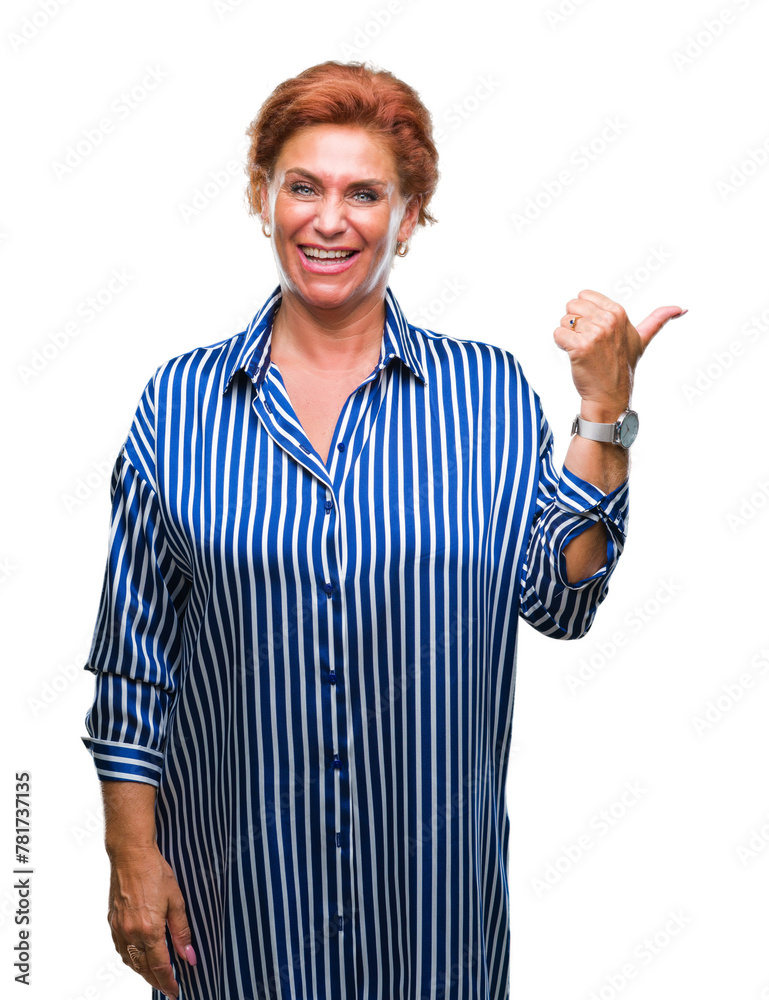 Poster Atrractive senior caucasian redhead woman over isolated background smiling with happy face looking and pointing to the side with thumb up.