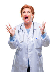 Senior caucasian doctor woman wearing medical uniform over isolated background crazy and mad shouting and yelling with aggressive expression and arms raised. Frustration concept.