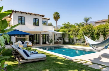 Foto op Canvas a small pool and outdoor living area in front, a modern house with white stucco walls and black steel frame construction. Patio furniture sits on a grassy area near the pool © Kien