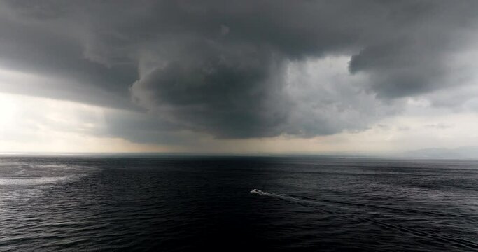 Speeding boat travels across ocean water surface, escape oncoming storm