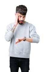 Young handsome man wearing sweatshirt over isolated background Looking at the watch time worried, afraid of getting late
