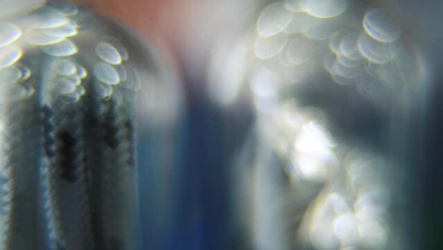Macro close up shot, USB wire in a round plastic cover, DREAMY BOKEH, charging cable in a glowing clear case. slide left smooth movement. Super slow motion 120 fps, Full HD