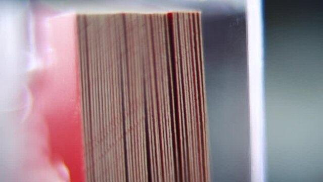 Macro shot of a pile of visit cards in stock, red card, super slow motion, Full HD, tilt down smooth movement