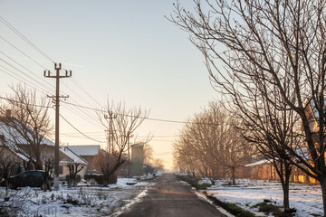 Panorama of a road and street in the village of crepaja, in Vojvodina, Banat, Serbia, in the countryside, during a cold freezing afternoon of winter with lots of snow. - obrazy, fototapety, plakaty