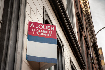 Selective blur on a french sign with the mention "a louer logements etudiants" meaning in french "student housing for rent" in a real estate operation in a french city.