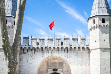 Entrance to Topkapi Palace from the Gate of Salutation, also known as Middle Gate or orta Kapi with a turkish flag in Istanbul, Turkey. Topkapi Palace was Castle Palace of the Ottoman Empire Sultans. - obrazy, fototapety, plakaty