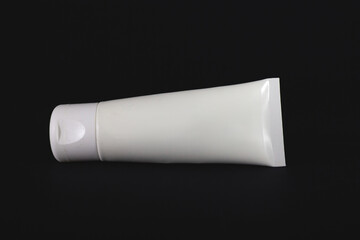 Studio shot of White cosmetics tube for cream and other skincare lotions isolated on a black background.