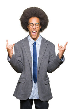 Young african american business man with afro hair wearing glasses shouting with crazy expression doing rock symbol with hands up. Music star. Heavy concept.