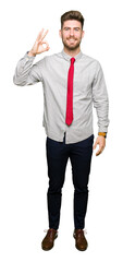 Young handsome business man smiling positive doing ok sign with hand and fingers. Successful expression.