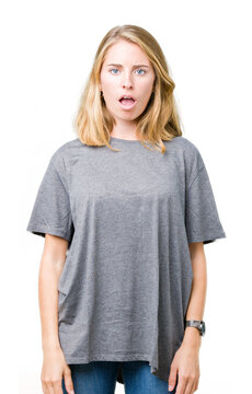 Beautiful young woman wearing oversize casual t-shirt over isolated background In shock face, looking skeptical and sarcastic, surprised with open mouth