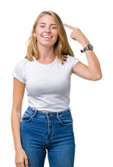 Fototapeta premium Beautiful young woman wearing casual white t-shirt over isolated background Smiling pointing to head with one finger, great idea or thought, good memory