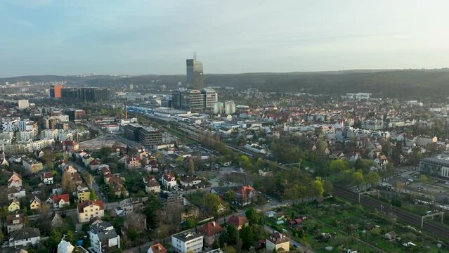 Aerial establishing shot of Gdansk Cityscape in Poland during golden sunrise. Olivia Business Centre in background. Wide shot orbiting.