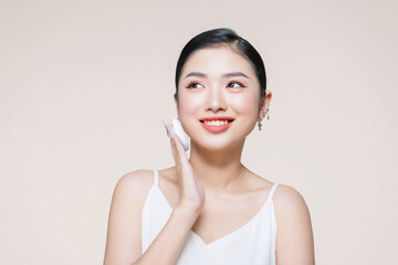 asian woman smile looking happy applying makeup with puff makeup to her face