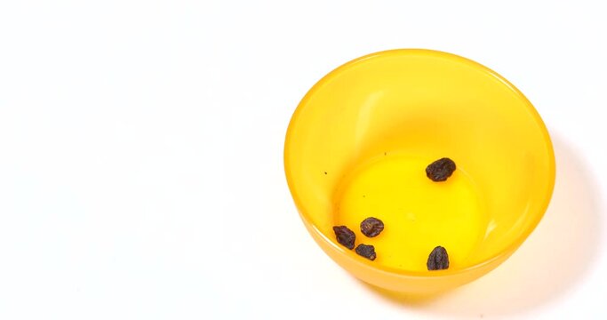 Bowl of fresh raisins getting cleaned, stop motion time lapse
