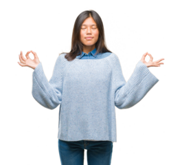 Young asian woman wearing winter sweater over isolated background relax and smiling with eyes closed doing meditation gesture with fingers. Yoga concept.