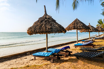 Umbrellas made of straw and chaise longue made of wood on a wonderful tropical beach, Beautiful...